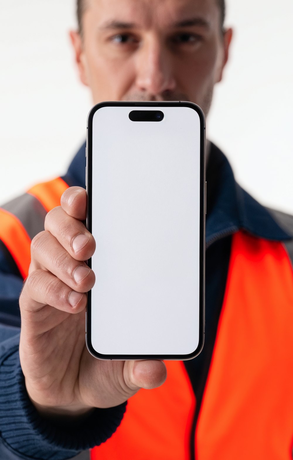 Un dépanneur en gilet orange tend son téléphone avec l'application TIOP Pro